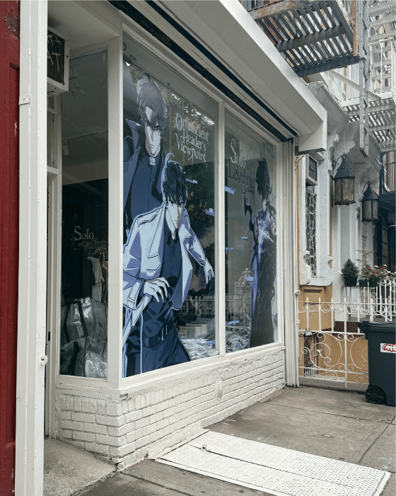 Street view of the System Sync NYC storefront with Solo Leveling and Omniscient Reader’s Viewpoint window artwork